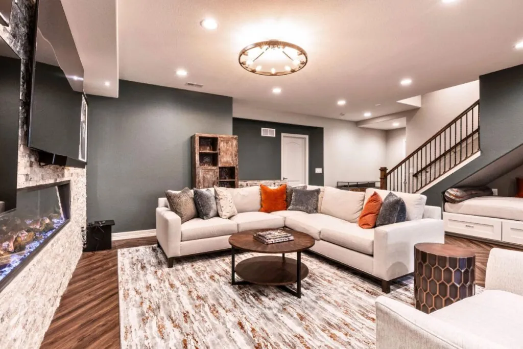 a beautifully renovated basement featuring sleek modern finishes, warm ambient lighting, and open space that invites creativity and relaxation.